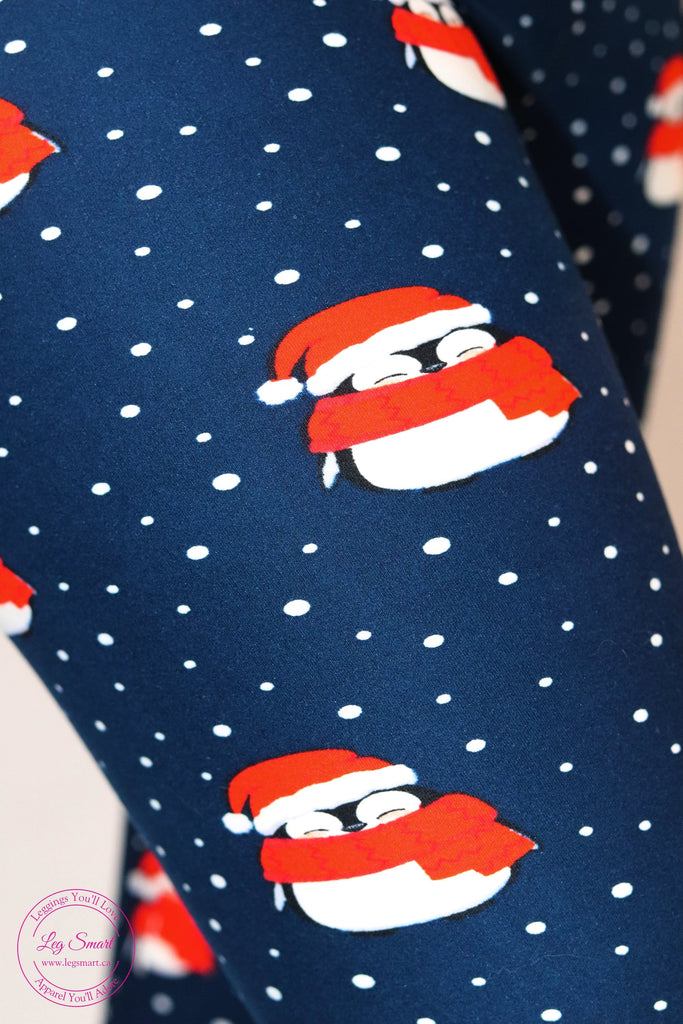 navy leggings feature an adorable print of penguins wearing a festive Christmas hat and scarf adorned with white snowflakes