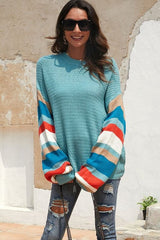 Robin's egg blue sweater with multi-coloured stripes on the sleeve