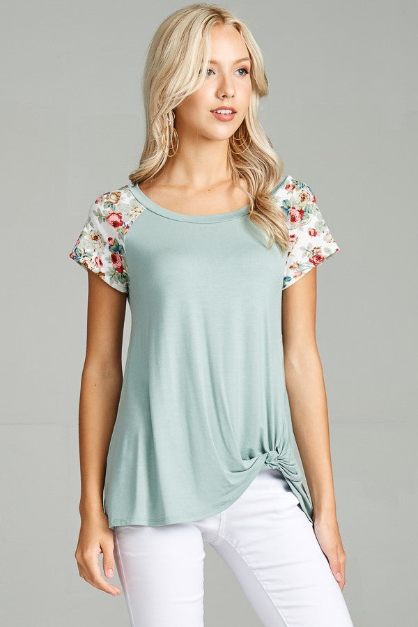 sage coloured t-shirt with a floral accent on the shoulders 