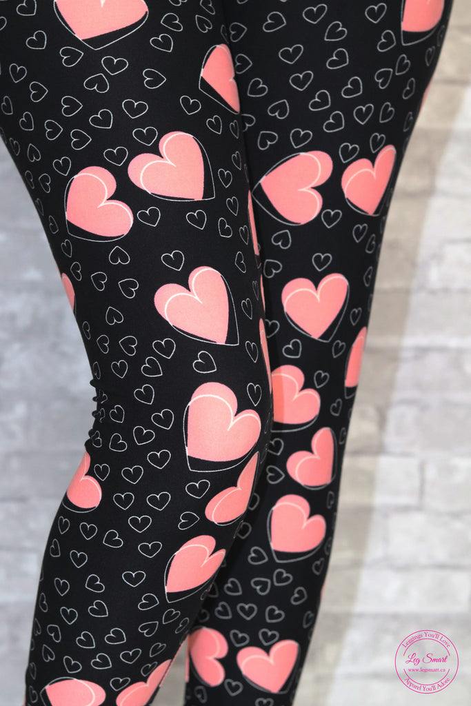 buttery soft, stretchy leggings with a black background with pink and white hearts